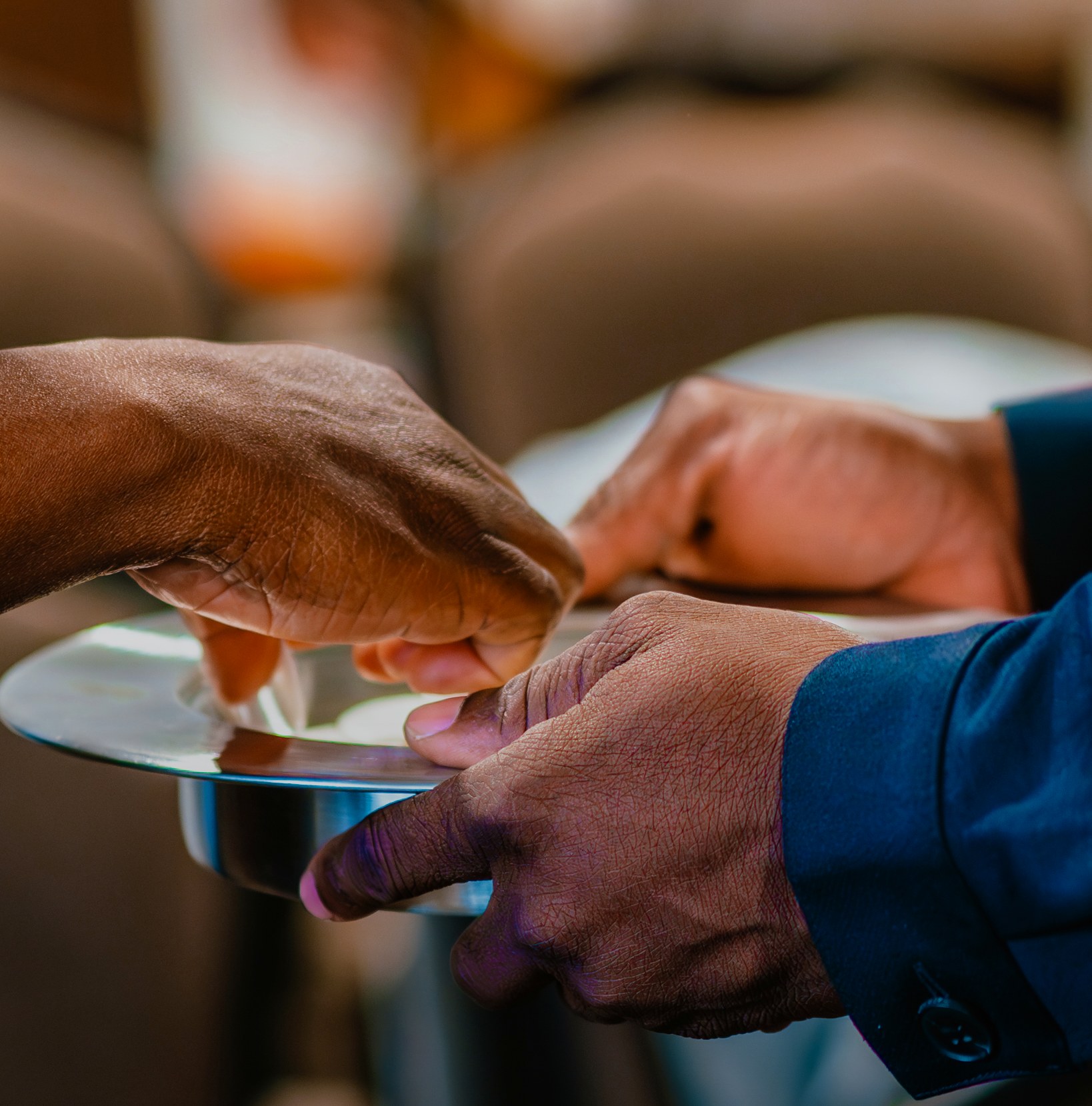 Hands sharing a plate during a church fellowship meal