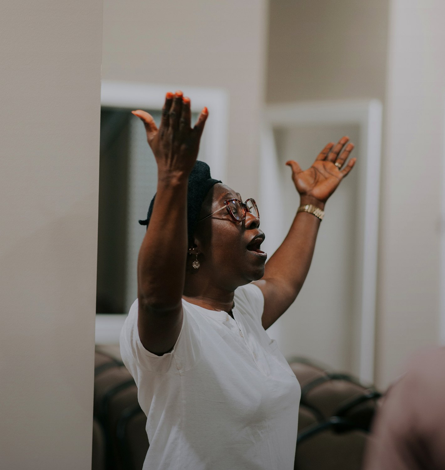 A woman with hands raised in prayer