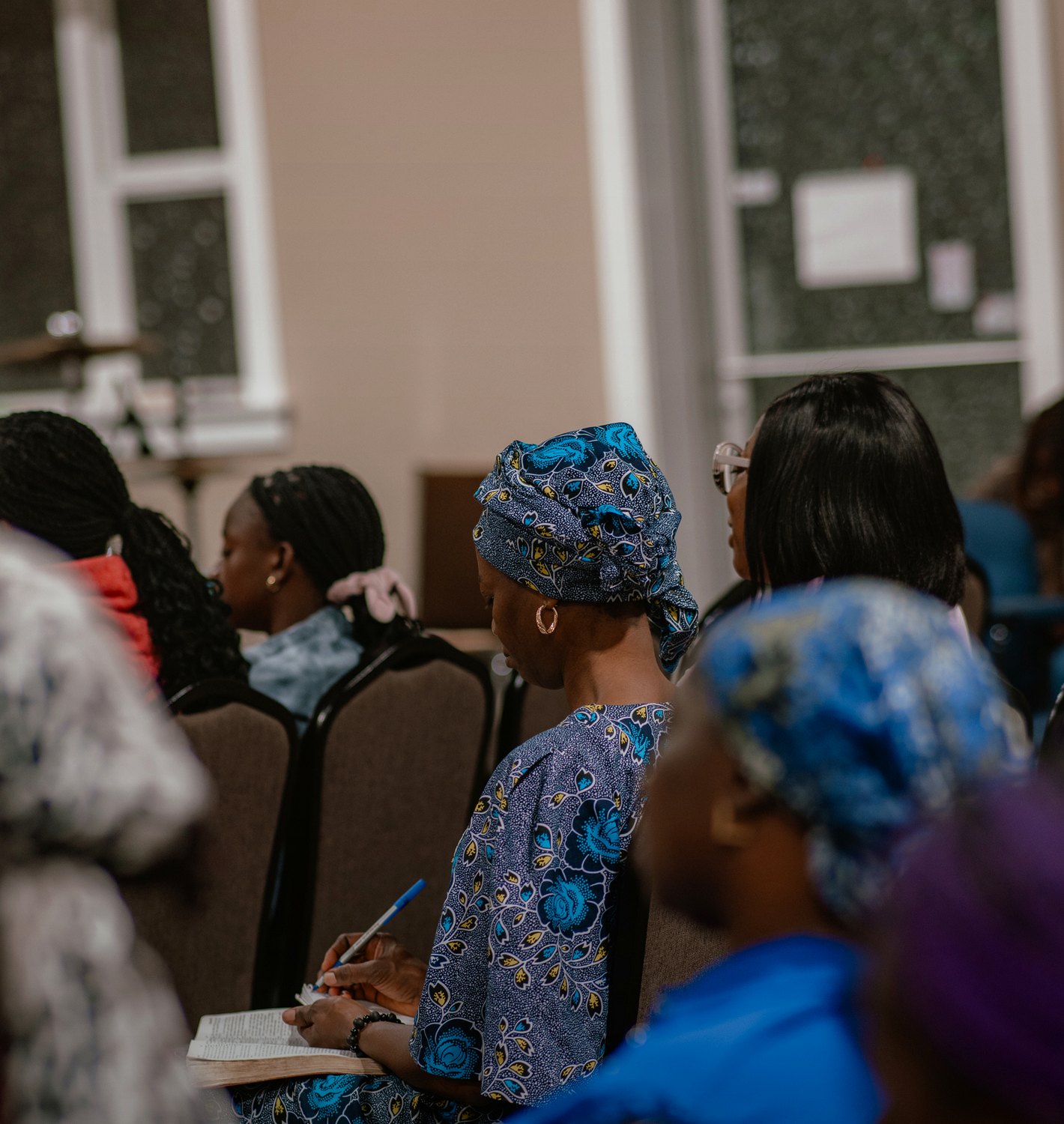 A church member taking notes with a Bible open
