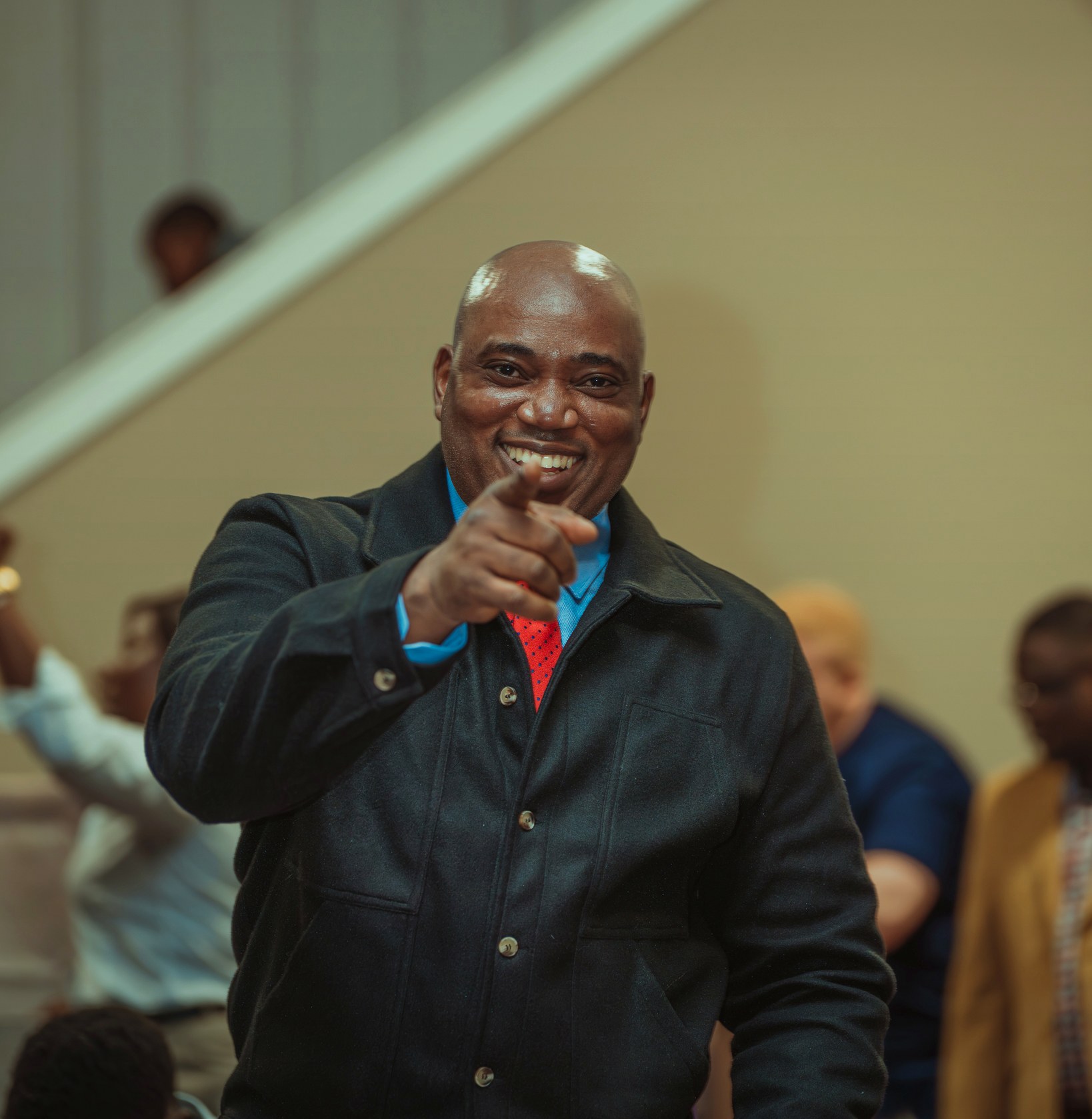 A church member smiling while holding a microphone